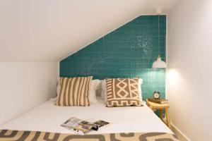 a bedroom with a bed with a green wall at Studio Blue LX- 1 de Maio in Lisbon