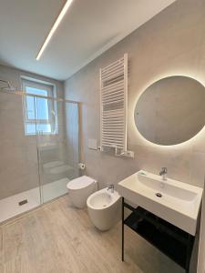 a bathroom with a sink and a toilet and a mirror at Residence Corallina in Caorle