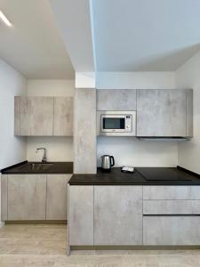 a kitchen with stainless steel cabinets and a microwave at Residence Corallina in Caorle +22 photos