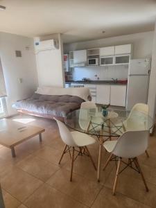 a room with a glass table and chairs and a bed at Plaza López in Rosario