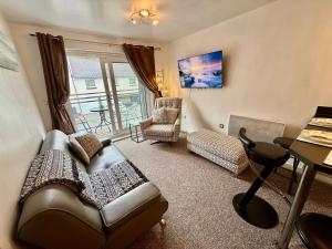 Bon-y-maenにあるCharming River Nest Near the Stadium and City Centre Comfort for Up to 4 Guestsのソファとテーブルのあるリビングルーム