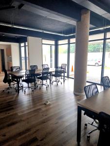 an empty room with tables and chairs and windows at Hermoso Departamento en alquiler, Edificio Agora I, Villa Rosa in La Lonja +18 photos