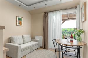 a living room with a table and a chair and a couch at Dolce Apartmanház in Eger