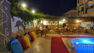 a patio with a pool and people sitting at a restaurant at Grand Didyma Hotel in Didim