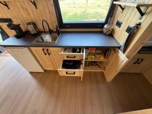 a small kitchen with a sink and a counter top at Maringotka za Lány in Příbram
