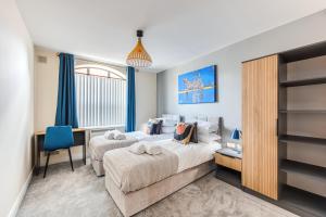 ダービーにあるMillhouse Apartment - City Centre - Free Parking, Self-Check-in, SkyTV and Fast Wifi by Yoko Propertyのベッド2台と机と窓のある寝室