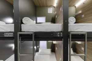 מיטה או מיטות קומותיים בחדר ב-Capsule Hotel Capsula
