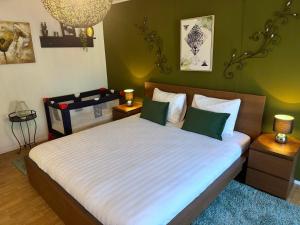a bedroom with a large bed with green walls at Villa Grenszicht in Nispen