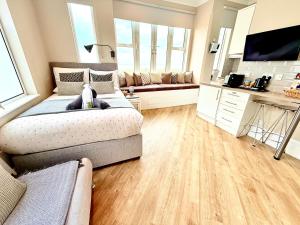 a large bedroom with a bed and a couch at Beachfront Compact Coastal Crib, DIRECT Sea Views & Air Conditioning in Littlestone-on-Sea