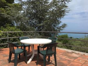 un tavolo e sedie su un patio con vista sull'oceano di Villa Master a Cefalù