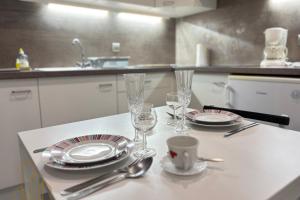 a table with plates and glasses on a kitchen counter at Le Ferdinand I - Cosy & Central in Roanne