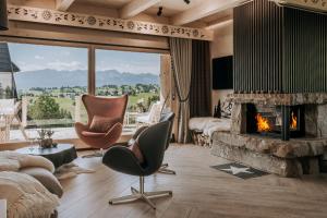 a living room with a fireplace and a view of mountains at Tatra Bjerge View in Zakopane