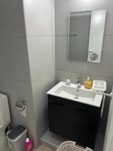 パラリムニにあるThe relaxing apartmentの洗面台と鏡のあるバスルーム +1枚の写真