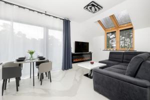 a living room with a couch and a table at Amber Baltic Apartment by Solarento in Niechorze