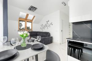a kitchen and living room with a table and a couch at Amber Baltic Apartment by Solarento in Niechorze