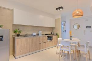 une cuisine avec un évier et une table avec des chaises dans l'établissement Fliphaus Mansion Mitre 'A' - 4 pax Duplex Gym & Jacuzzi, à Buenos Aires