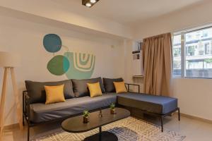 un salon avec un canapé et une table dans l'établissement Fliphaus Mansion Mitre 'A' - 4 pax Duplex Gym & Jacuzzi, à Buenos Aires 13 autres photos