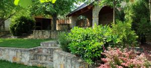 a garden with a stone wall and some bushes at La Boier in Bălţi