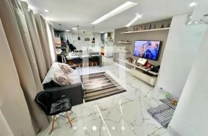 a living room with a tv on a wall at Aconchego de Lugar - Eri & Douglas in Belo Horizonte