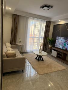Una sala de estar con un sofá, una mesa y un televisor. en City homes, en Nairobi
