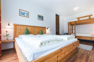 ein Schlafzimmer mit einem großen Bett mit weißer Bettwäsche in der Unterkunft Apparthotel AlpenChalet in Neukirchen am Großvenediger