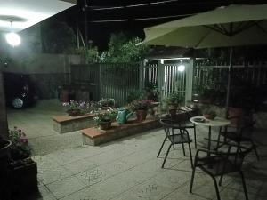 a patio with a table and chairs and potted plants at La Casa nel Verde, tra mare e Vesuvio in Boscotrecase