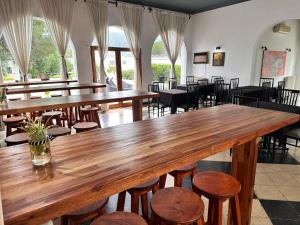 einem großen Holztisch in einem Restaurant mit Stühlen in der Unterkunft Hostal de la Costa in Villa Carlos Paz