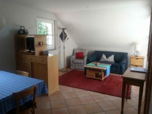 sala de estar con sofá azul y mesa en Weingut Wissler - Brennerei, en Au
