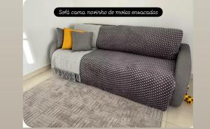 a couch sitting in a room with a rug at Apartamento super central até 9 pessoas in Divinópolis