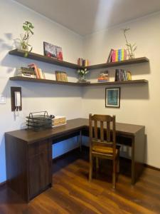 a desk with a chair and shelves on the wall at Garden Suite in Cochabamba +6 photos