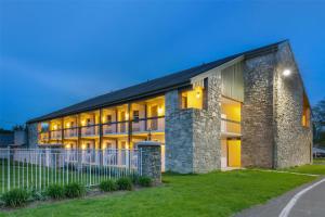 a large brick building with a fence in front of it at SureStay Studio by Best Western Paradise Lancaster County in Paradise