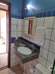 a bathroom with a sink and a mirror at Buzios Suites - com Garagem in Búzios