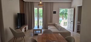 una sala de estar con un sofá y una mesa en Amelia's Garden, en Kavos