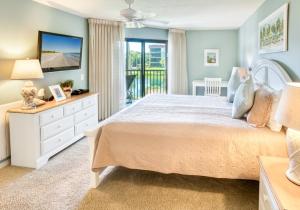 a bedroom with a large bed and a balcony at Pointe Santo D27 condo in Sanibel +16 photos