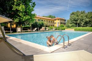 two women are sitting in a swimming pool at Agriturismo Lemene in Caorle
