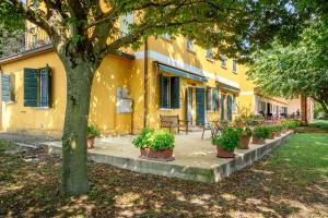 a yellow building with potted plants in front of it at Agriturismo Lemene in Caorle
