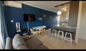 a living room with a couch and a kitchen at 84 Camarque Umdloti beach in Umdloti
