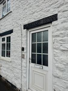 a white brick building with a door and windows at Fryers Cottage 3 Bedroom Sleeps 6 Cottage in Scarborough