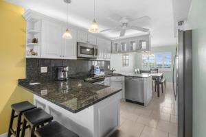 a kitchen with white cabinets and a counter top at Sandpebble 3F condo in Sanibel