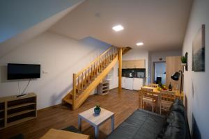 a living room with a couch and a staircase at Apartmány Na handě in Boží Dar