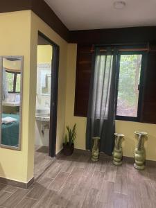 a room with a bathroom with a mirror and a sink at Cabañas Xpujil Calakmul Campeche con vista a la Selva in Xpujil