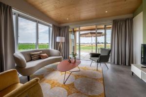 una sala de estar con un sofá y una mesa en Landgoed Oud Bommenede, en Zonnemaire