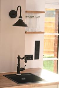 a kitchen sink with a black faucet at Ferienwohnung Lämmche, EG mit eingezäuntem Garten in Polling