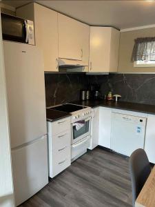 a kitchen with white appliances and black counter tops at Leilighet i Sør-Fron kommune in Sør-Fron +21 photos
