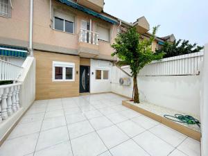 a patio with a tree in front of a house at Flor De Sal Villa in San Pedro del Pinatar
