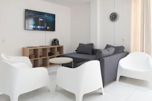a living room with a couch and white chairs at edificio Alba in Cartagena de Indias