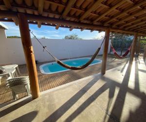 Casa Vermelha Corumbau في كورومباو: شرفة مع أرجوحة وحمام سباحة