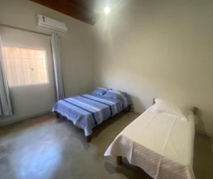 Casa Vermelha Corumbau في كورومباو: غرفة بسريرين في غرفة بها نافذة +46 صورة