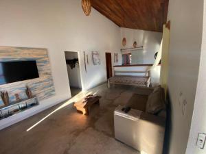 Casa Vermelha Corumbau في كورومباو: غرفة معيشة مع أريكة وتلفزيون