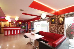 a living room with a red couch and a table at Hotel O Sher E Bengal in Durgāpur